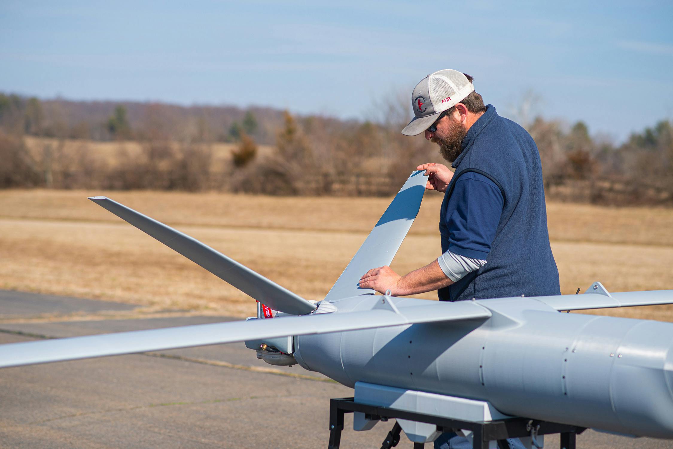 An M2 UAS being adjusted by a RapidFlight team member